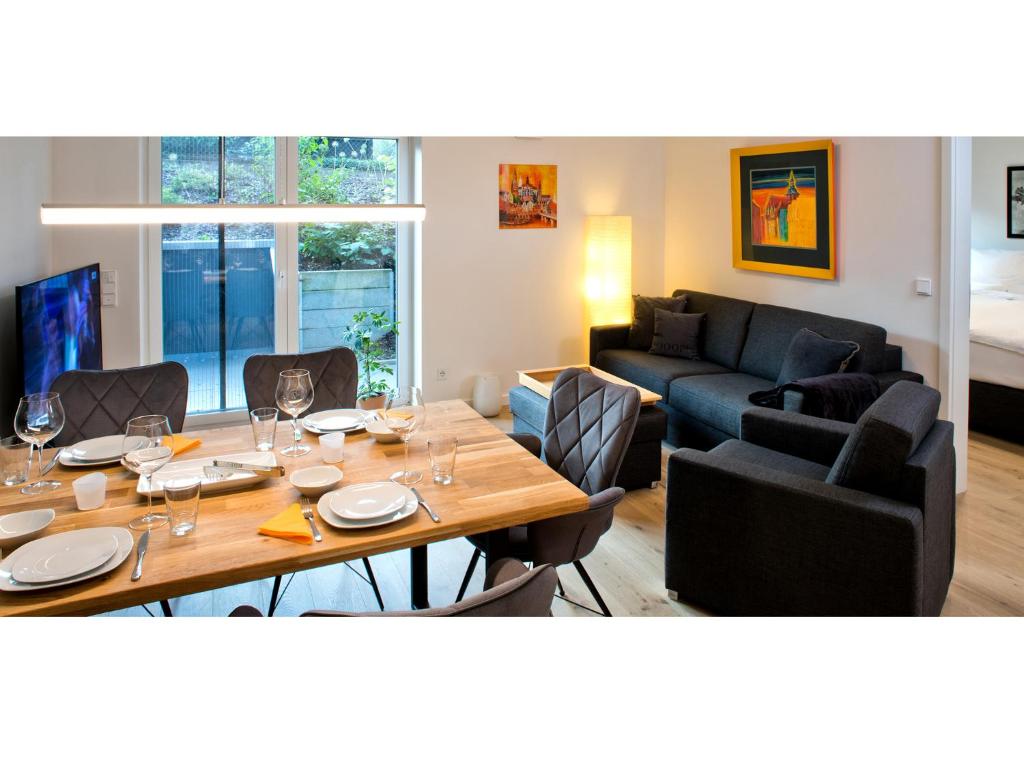 ein Esszimmer und ein Wohnzimmer mit einem Tisch und einem Sofa in der Unterkunft Landhaus Lueneburg Komfort Apartment in Lüneburg