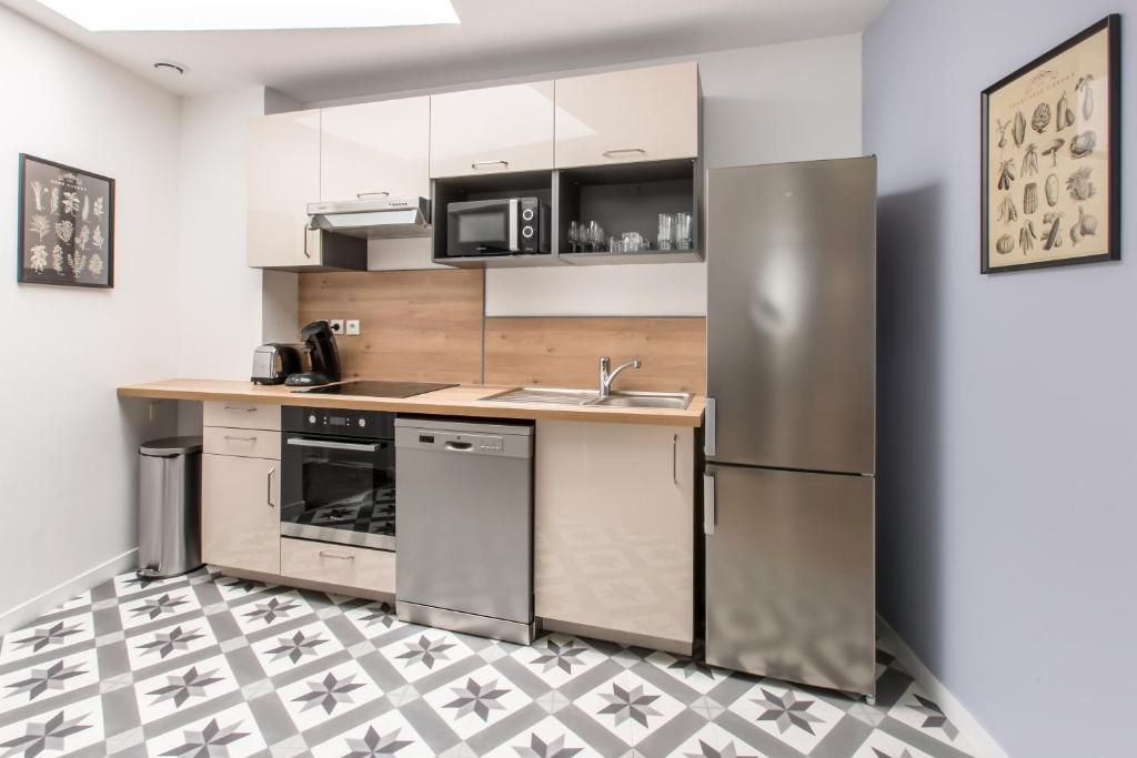 a kitchen with stainless steel appliances and a tile floor at STAR WARS in Tourcoing