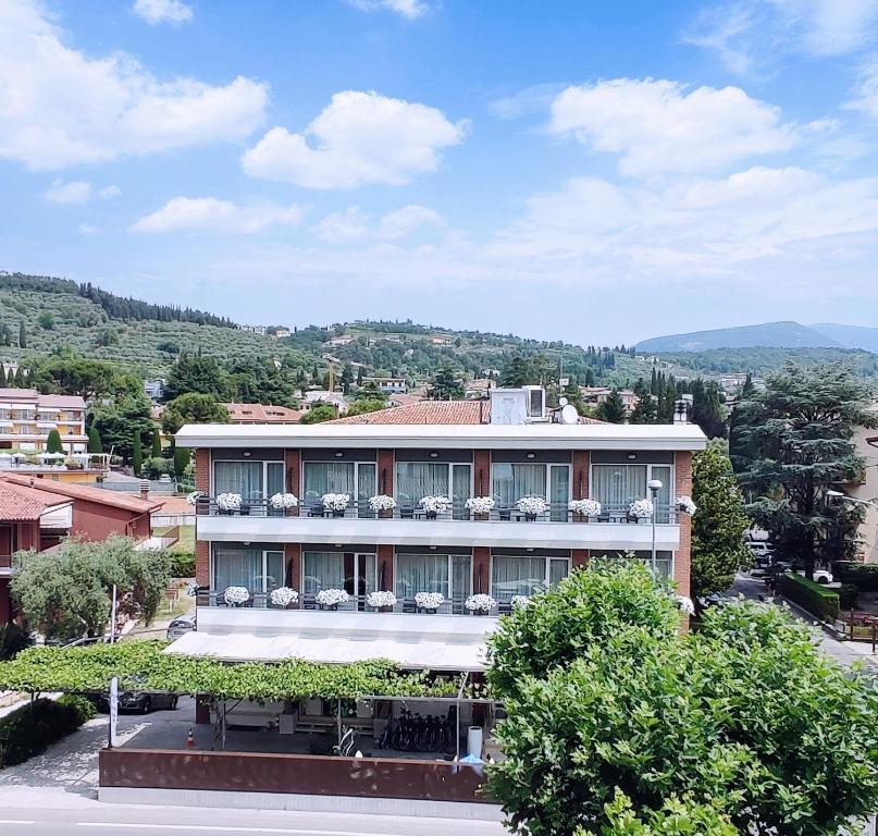 un edificio con plantas a su lado en Hotel Benaco Garda ***S en Garda