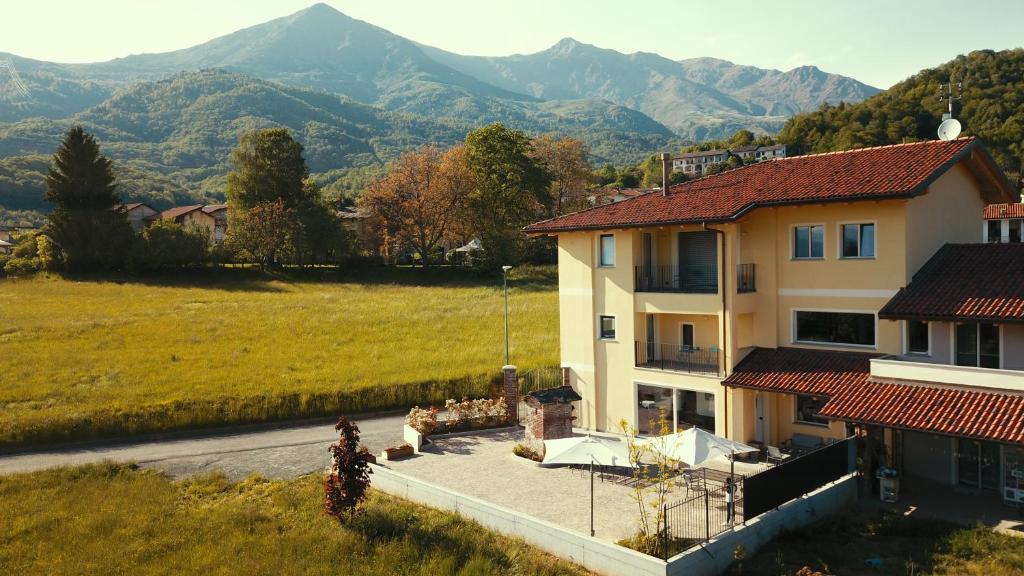 une grande maison avec des montagnes en arrière-plan dans l'établissement HOTELLERIE VALLE SACRA, à Cintano