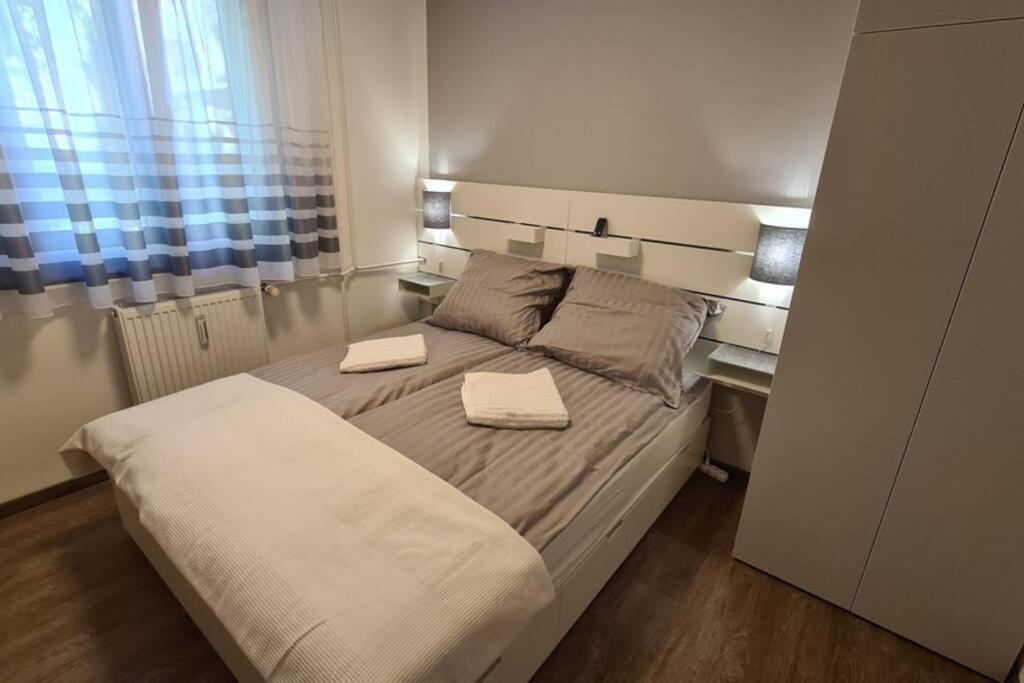 a bedroom with a bed with two towels on it at Kadarka apartman - Szekszárd in Szekszárd