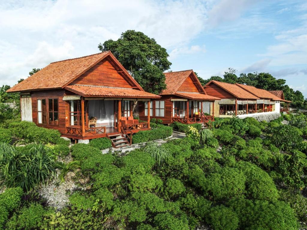 a row of wooden houses in a forest at Marind Dive Eco Resort in Waha