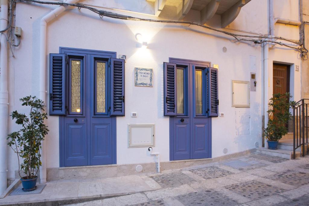a white house with blue doors and windows at Al Baglio in Castellammare del Golfo