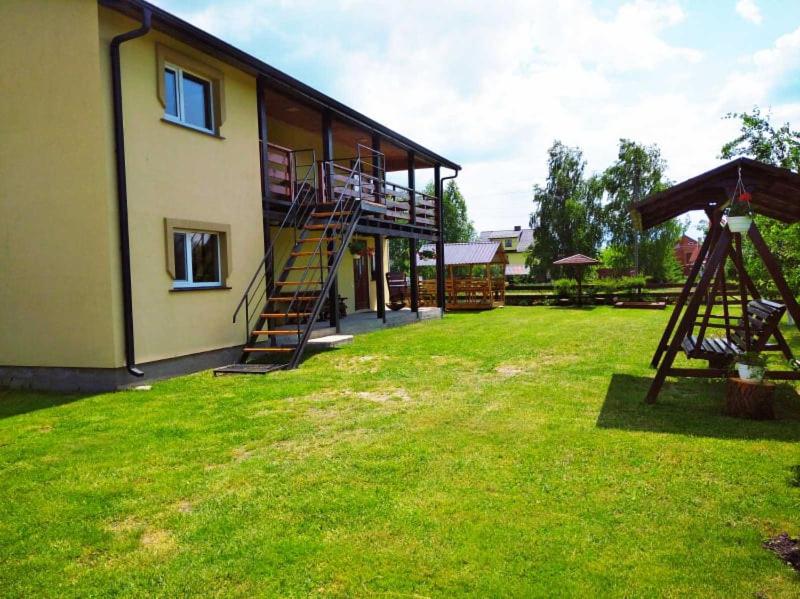a building with a grassy yard with a house at Цвіт лілії in Szack