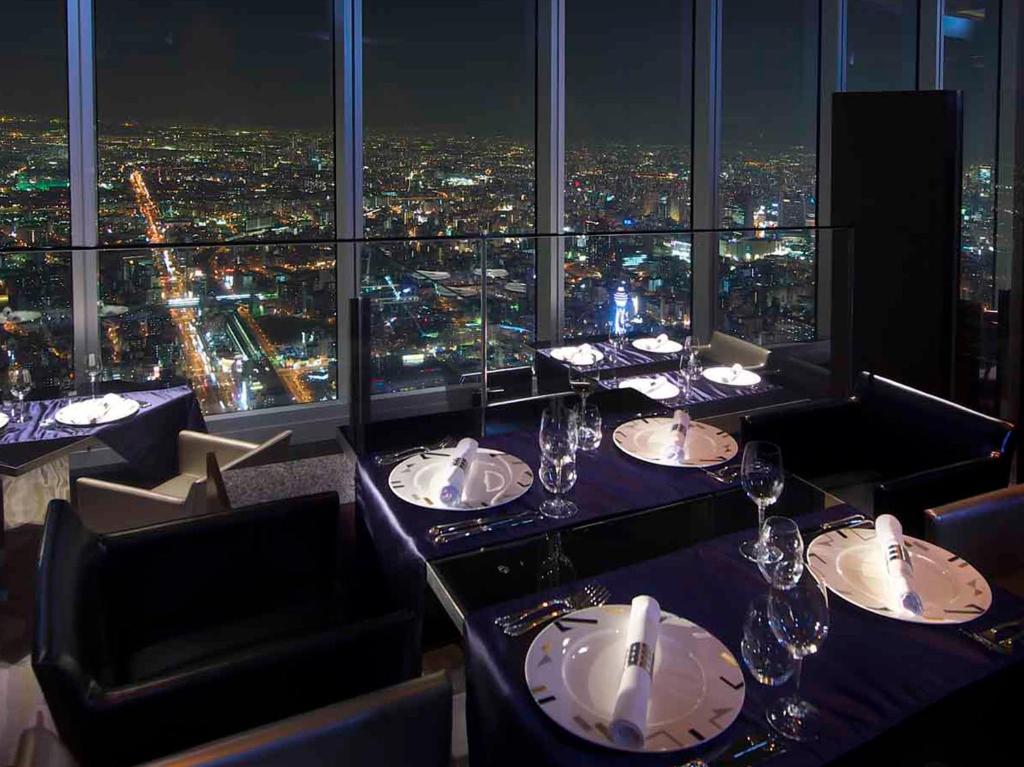 a restaurant with a view of a city at night at Osaka Marriott Miyako Hotel in Osaka