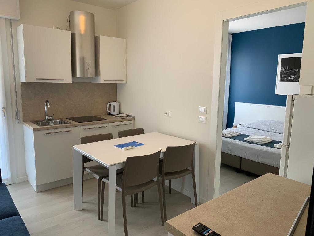 a small kitchen with a table and chairs and a bed at MAR60 Apartments in Caorle