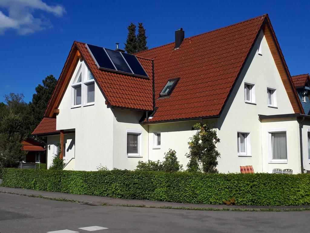 阿爾高地區旺根的住宿－Ferienwohnung Kitzelmann，一座房子,屋顶为红色,上面有太阳能电池板