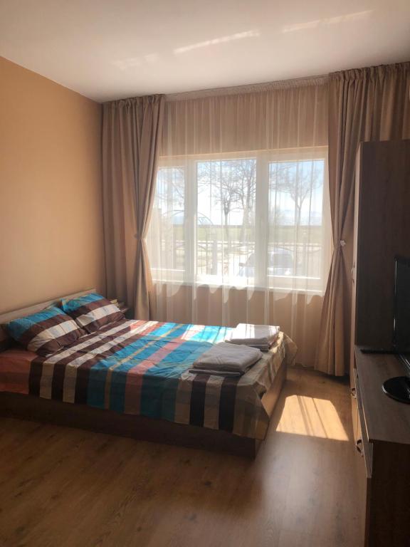 a bedroom with a bed in front of a window at Апартамент Върбанови in Pomorie