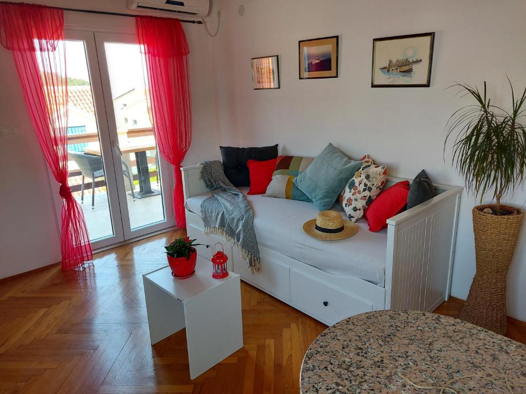 sala de estar con sofá y almohadas coloridas en Apartmani Štambuk, en Jelsa