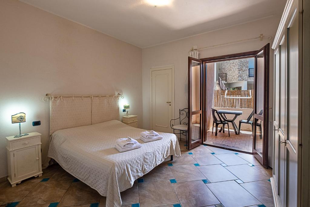 una camera da letto con un letto e due asciugamani di Giaco's Rooms a Villasimius