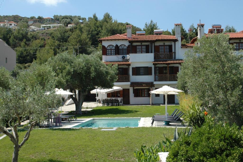 a large house with a swimming pool in front of it at Cielle Epoque in Pefkohori