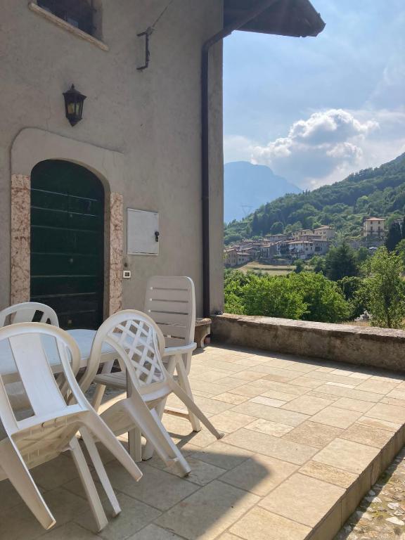 two white chairs and a table on a patio at Casa Milanda in Gargnano