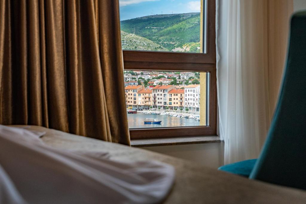 a room with a window with a view of a harbor at Hotel Meduza in Senj