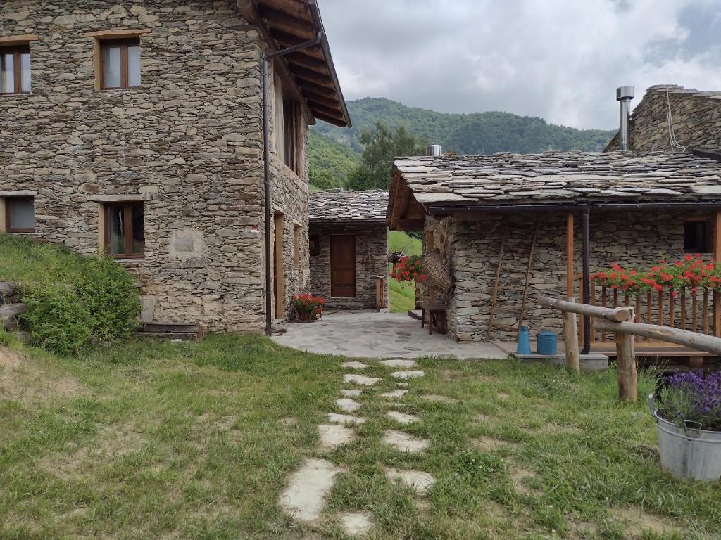 una casa de piedra con un camino que conduce a un patio en Le Baite di Baudinet - Trek&Relax, en Chiusa di Pesio
