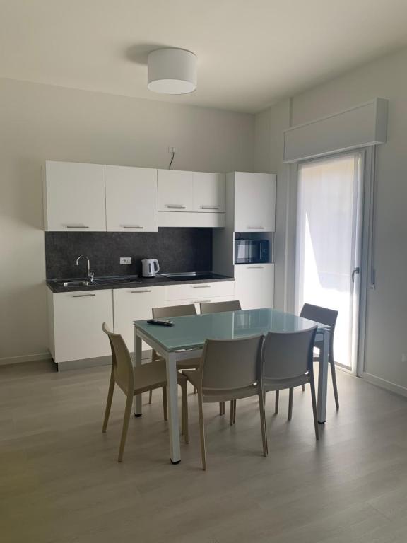 a kitchen with a table and chairs in a room at MAR60 Apartments in Caorle