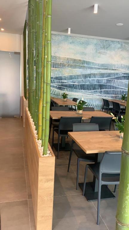 a restaurant with wooden tables and chairs and a painting at MAR60 Apartments in Caorle
