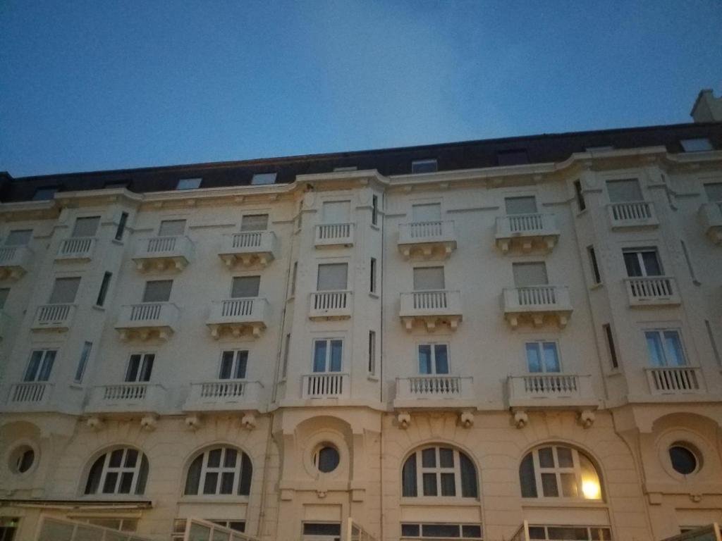 un gran edificio blanco con ventanas y balcones en Les Echappées Belles - Studio du phare en Biarritz