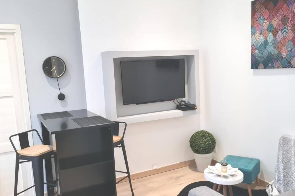 sala de estar con TV de pantalla plana en la pared en T2 tout neuf au coeur des commerces de Montchat, en Lyon