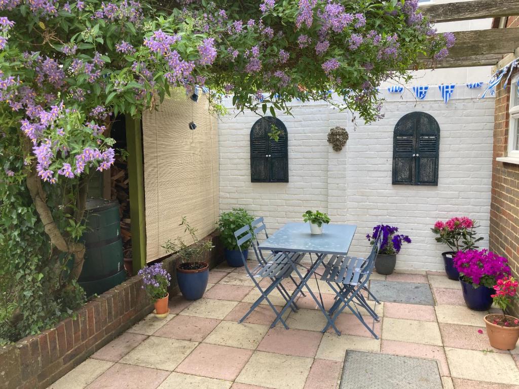 a table and chairs on a patio with flowers at Hillview in Saint Margaretʼs at Cliffe