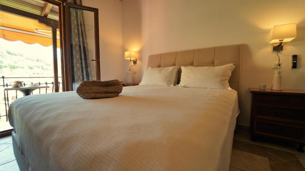 Un dormitorio con una gran cama blanca y una ventana en Hotel Tourist en Parga