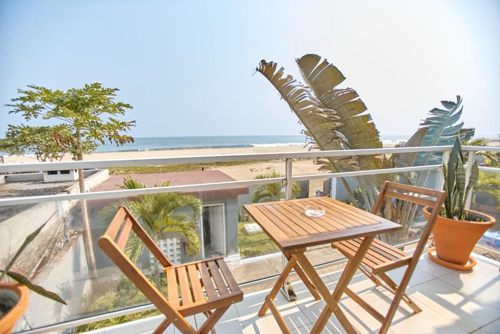 un tavolo e due sedie su un balcone con la spiaggia di Appartement - Vue sur mer a Pointe-Noire