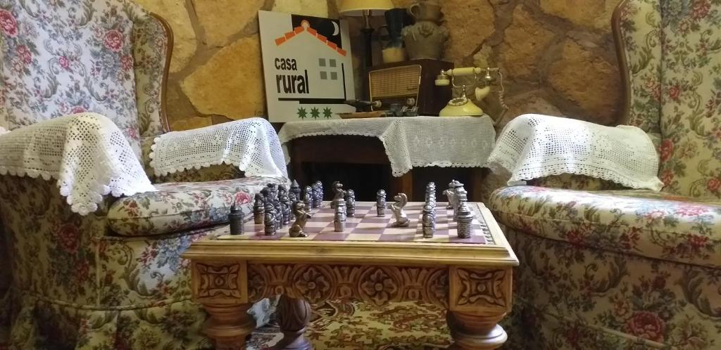 um tabuleiro de xadrez numa mesa numa sala com duas cadeiras em BOTEROS casa rural em Ayllón