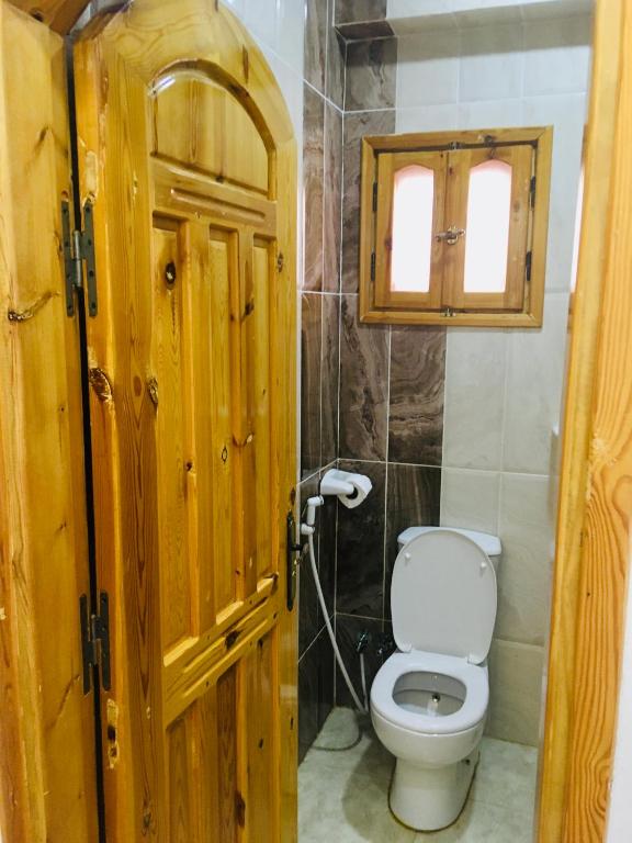 a bathroom with a toilet and a wooden door at Villa 22 in Dahab