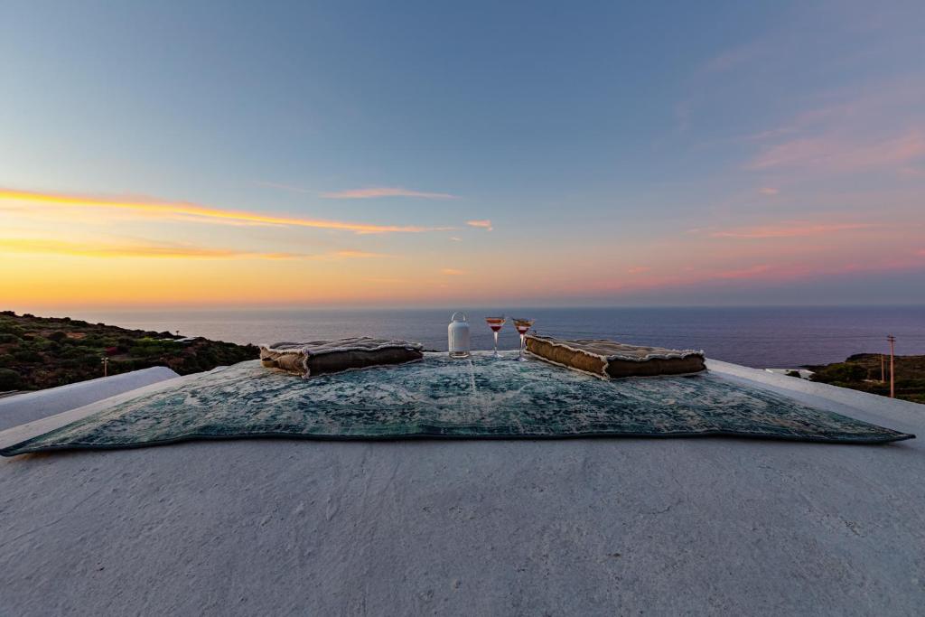 a table on a roof with the ocean in the background at Pantelleria Dream Resort in Pantelleria