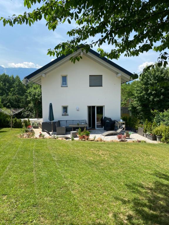 Biały dom z trawnikiem przed nim w obiekcie Arcana w mieście Seeboden