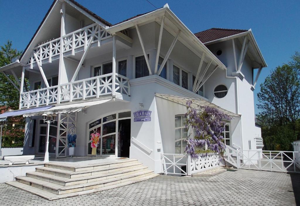 un gran edificio blanco con escaleras delante en Lila Ház en Harkány