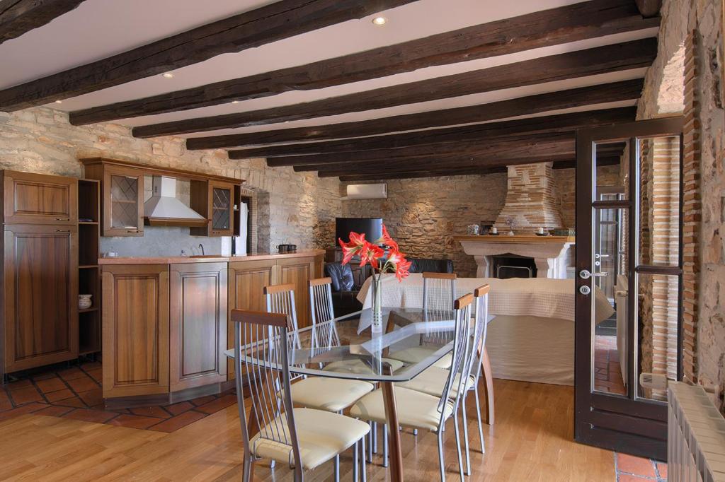 a kitchen and dining room with a glass table and chairs at Holiday Home Kukurin in Bale