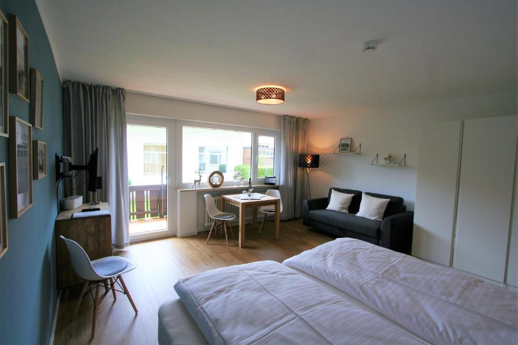 ein Schlafzimmer mit einem Bett, einem Sofa und einem Tisch in der Unterkunft Alpenflair Ferienwohnung 111 Nebelhorn in Oberstdorf