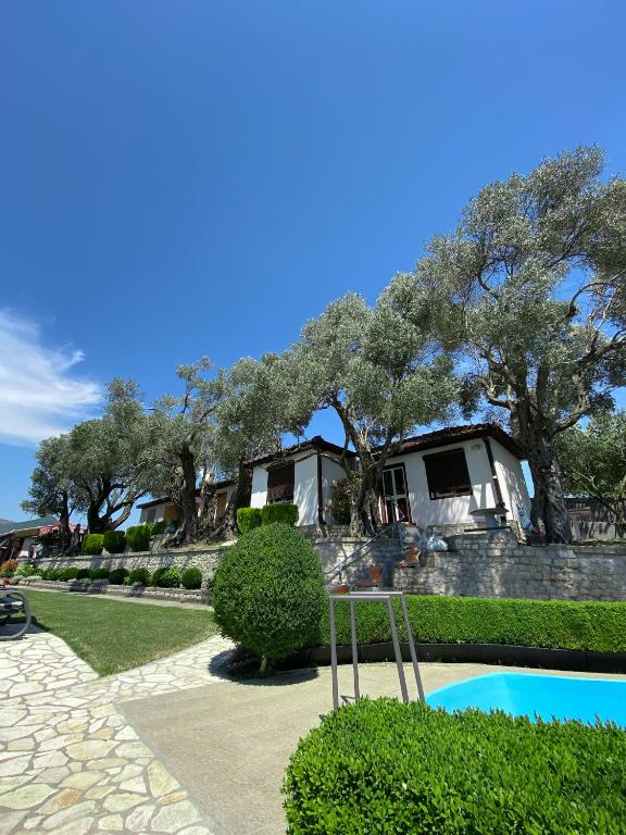 a house with a pool in front of a yard at Hilja's Oliven Garden Bungalows in Ulcinj