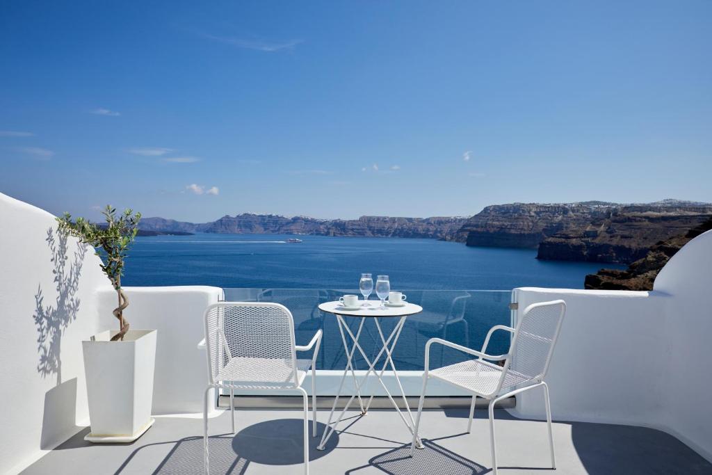 a table and chairs on a balcony overlooking the water at Santorini View in Akrotiri