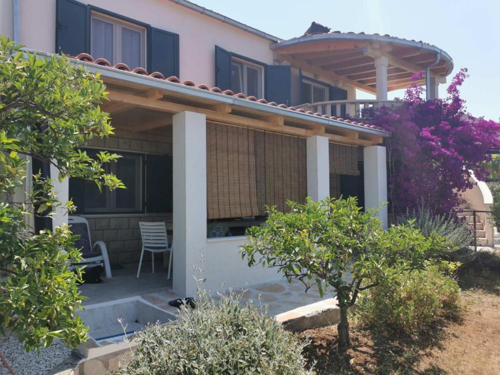 a house with a pergola and a chair on a patio at Apartment Miljenko Tomić in Splitska