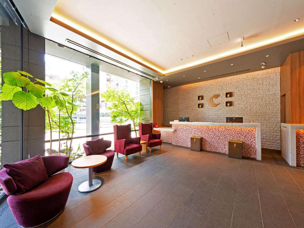 un hall avec des chaises et un bar dans un bâtiment dans l'établissement Comfort Inn Fukuoka Tenjin, à Fukuoka