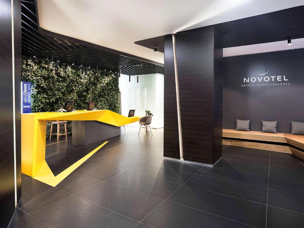 a lobby with a yellow table in a building at Novotel St Petersburg Centre in Saint Petersburg