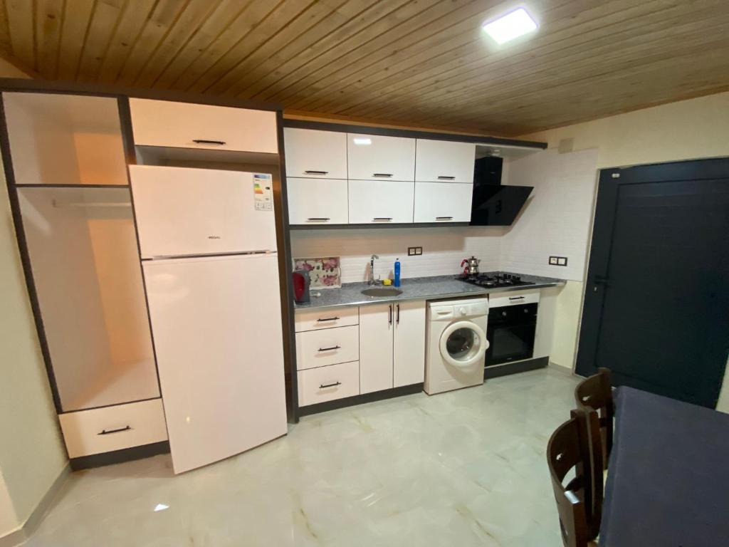 a kitchen with a refrigerator and a washing machine at Beyoglu Pansiyon in Patara