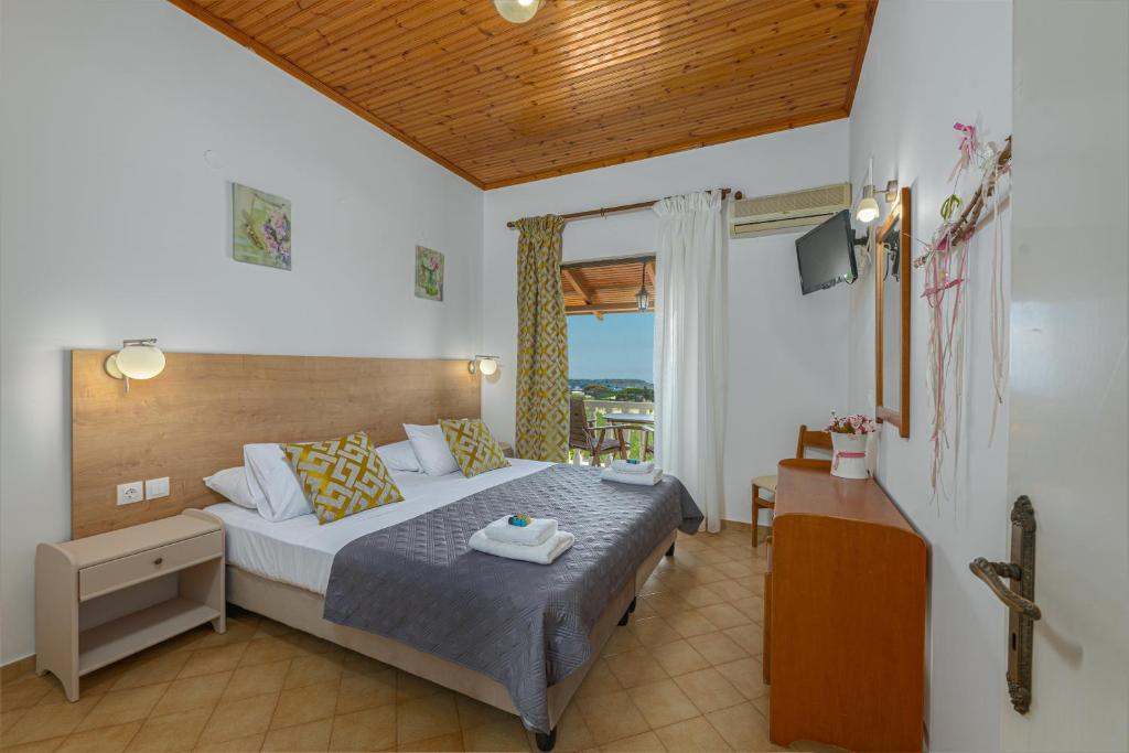 a bedroom with a bed and a television in it at Villa Kapnisi in Vasilikos