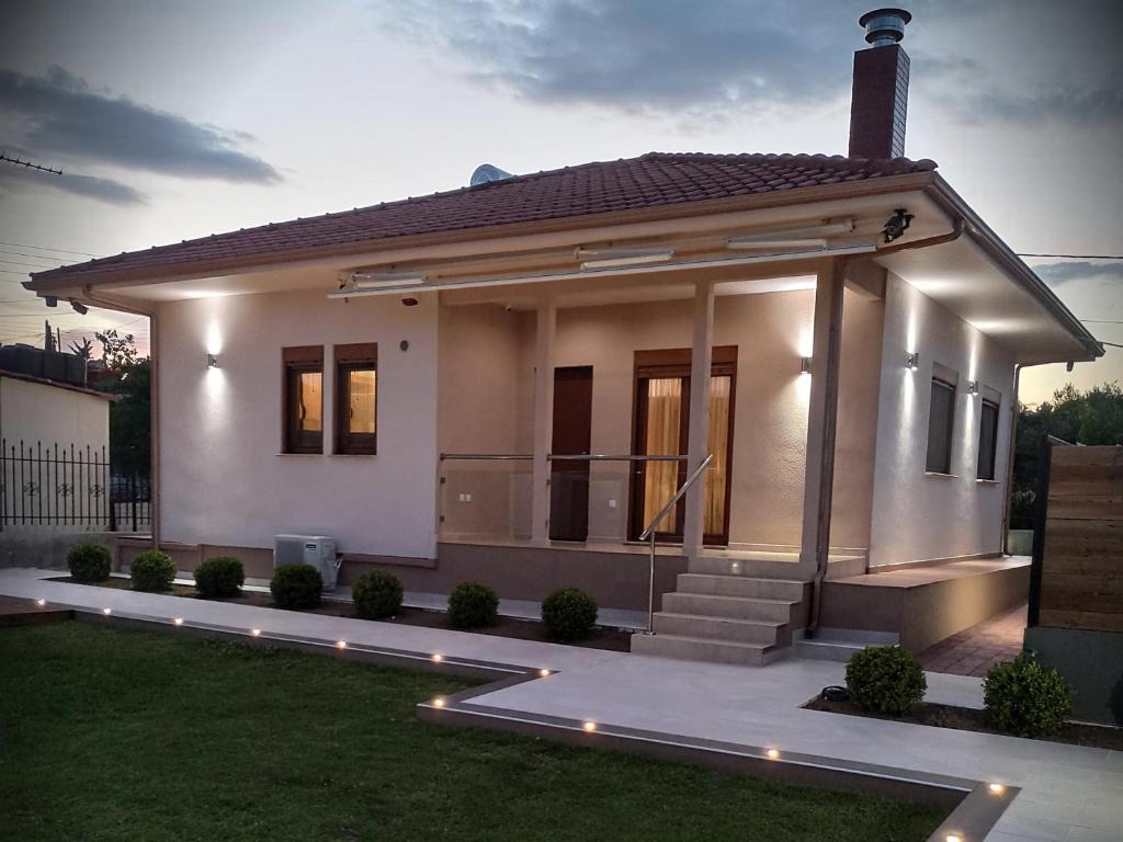 mały biały dom z oświetleniem na trawie w obiekcie Villa Rêve w miejscowości Nea Kallikratia