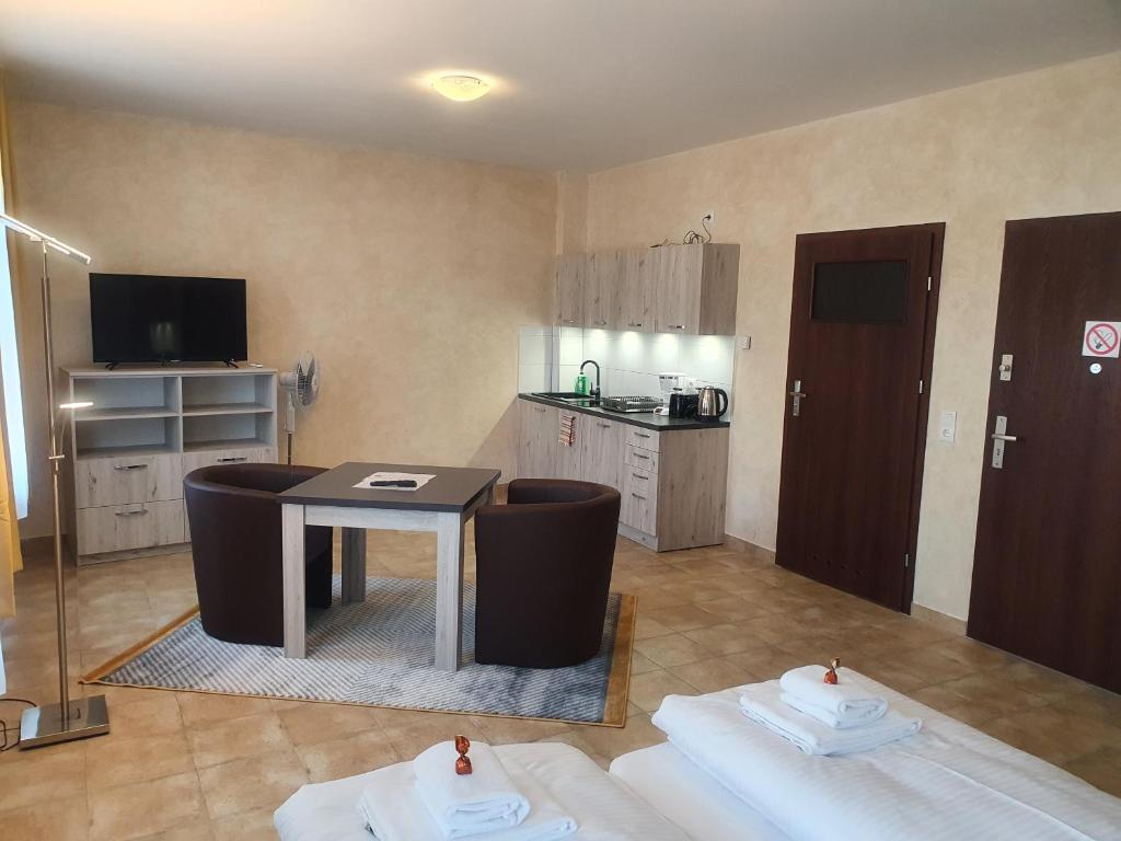 Zimmer mit einem Tisch und Stühlen sowie einer Küche in der Unterkunft Apartments Oberschlesien in Görlitz