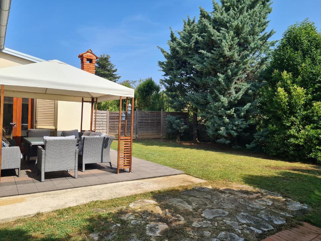 a backyard with a gazebo with chairs and an umbrella at Apartment Sidro in Poreč