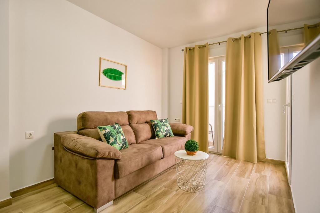 un soggiorno con divano e tavolo di Apartments CURA BEACH a Torrevieja