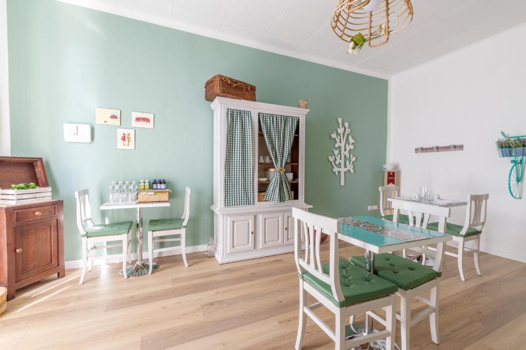 jadalnia z zielonymi ścianami oraz stołem i krzesłami w obiekcie Dama Bed & Breakfast w mieście Foligno