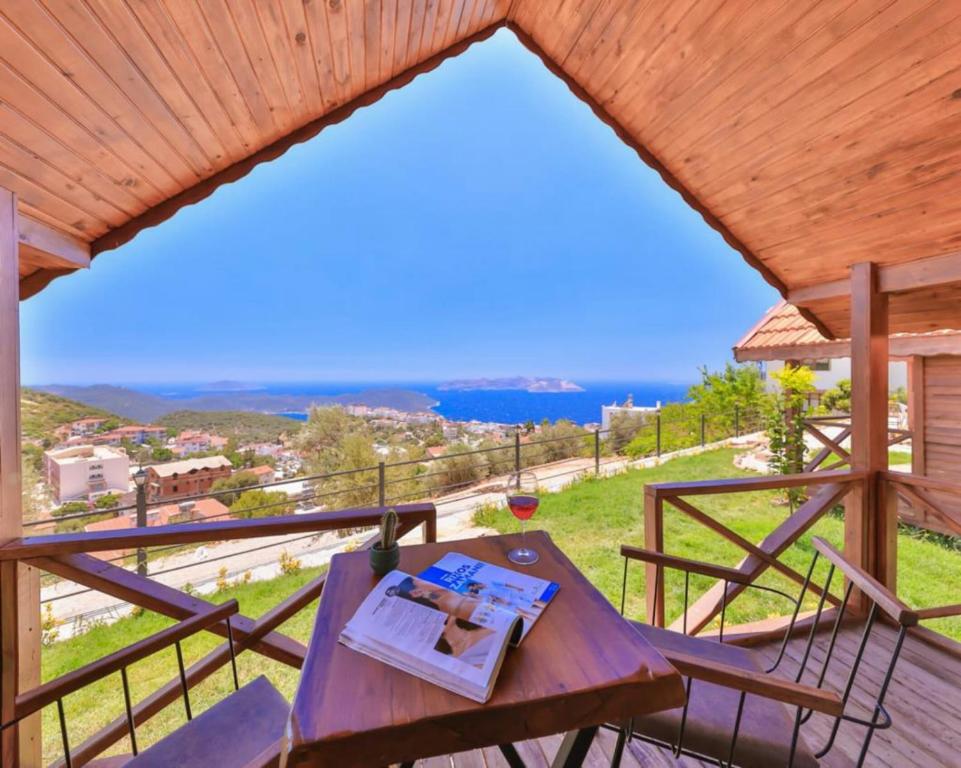 a wooden table on a deck with a view of the ocean at Ali's Bungalow in Kas