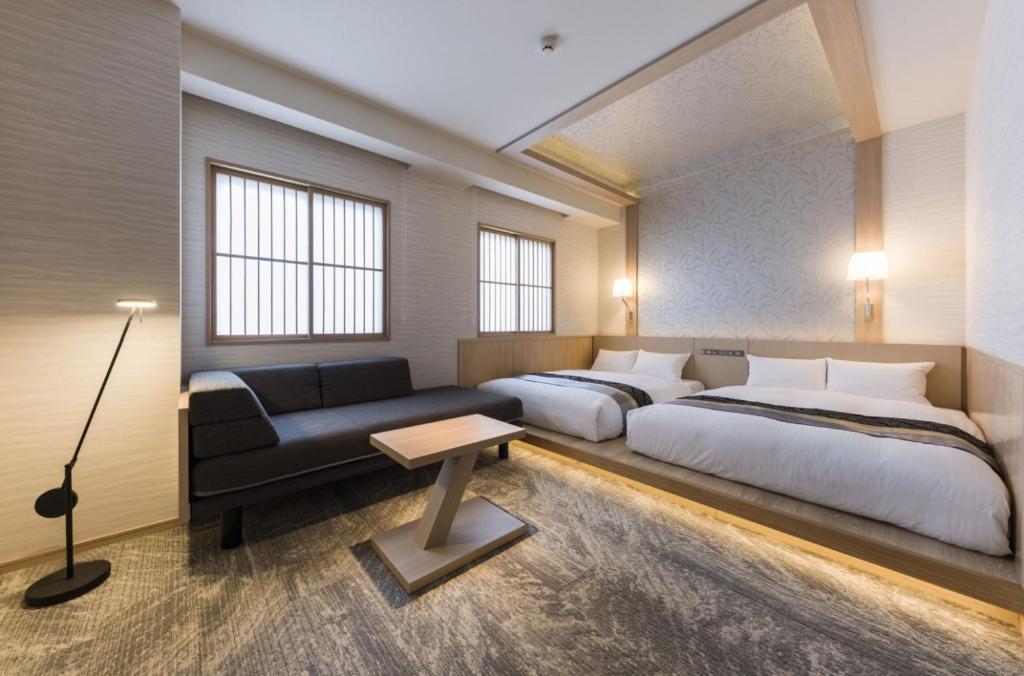 a bedroom with two beds and a couch at IAM HOTEL in Osaka