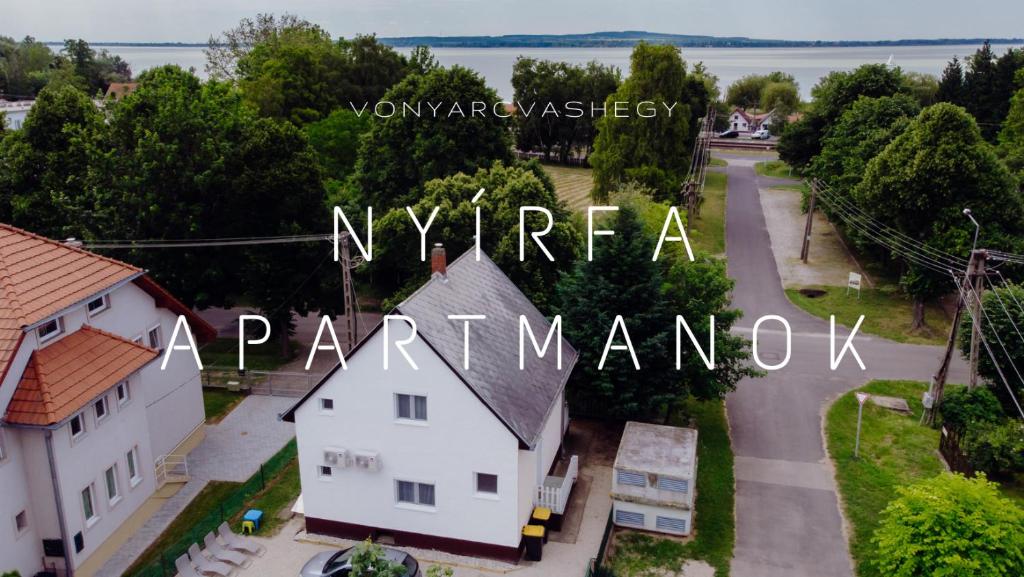 Luftblick auf ein weißes Haus und eine Straße in der Unterkunft Nyírfa Apartman in Vonyarcvashegy