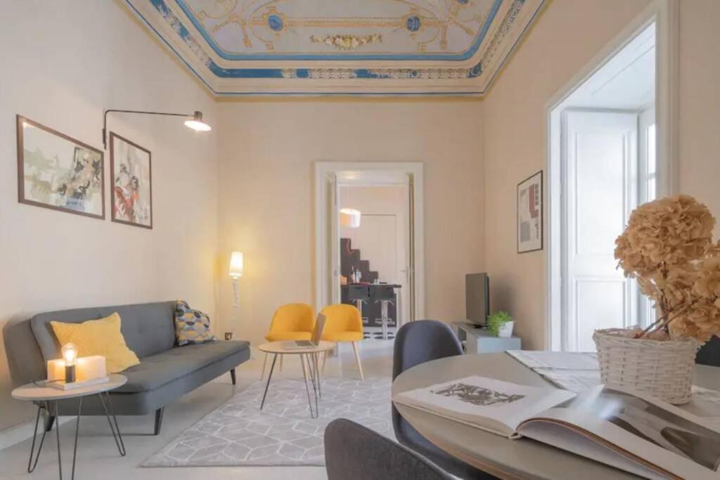 een woonkamer met een bank en een tafel bij Appartamento Nobiliare Design a 2 passi dal mare in Cefalù