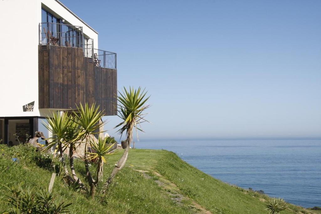 un edificio en una colina junto al océano en Agroturismo Haitzalde B&B - Adults Only en Mutriku