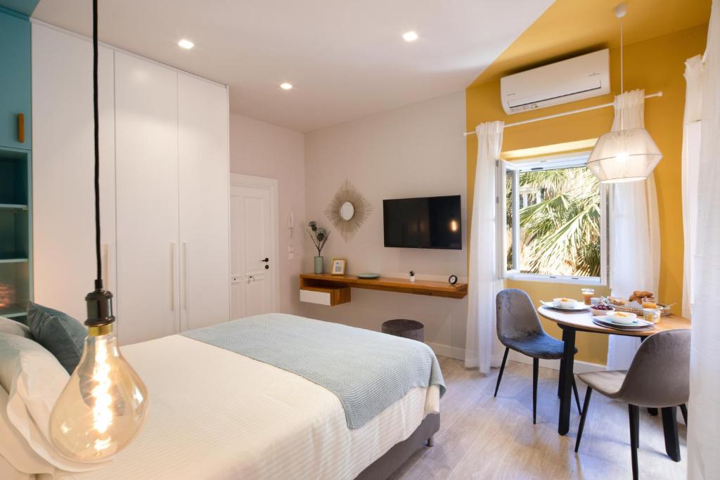 a bedroom with a bed and a table with chairs at Corfu Town Twin Studios- Liston area in Corfu